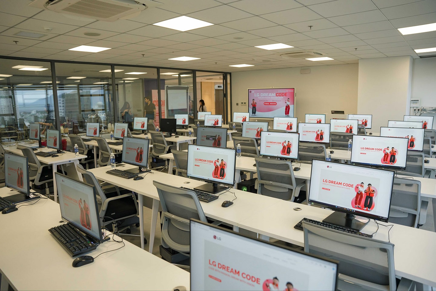 A photo of LG Dream Code program page shown on the screen of a number of computers in an empty computer lab