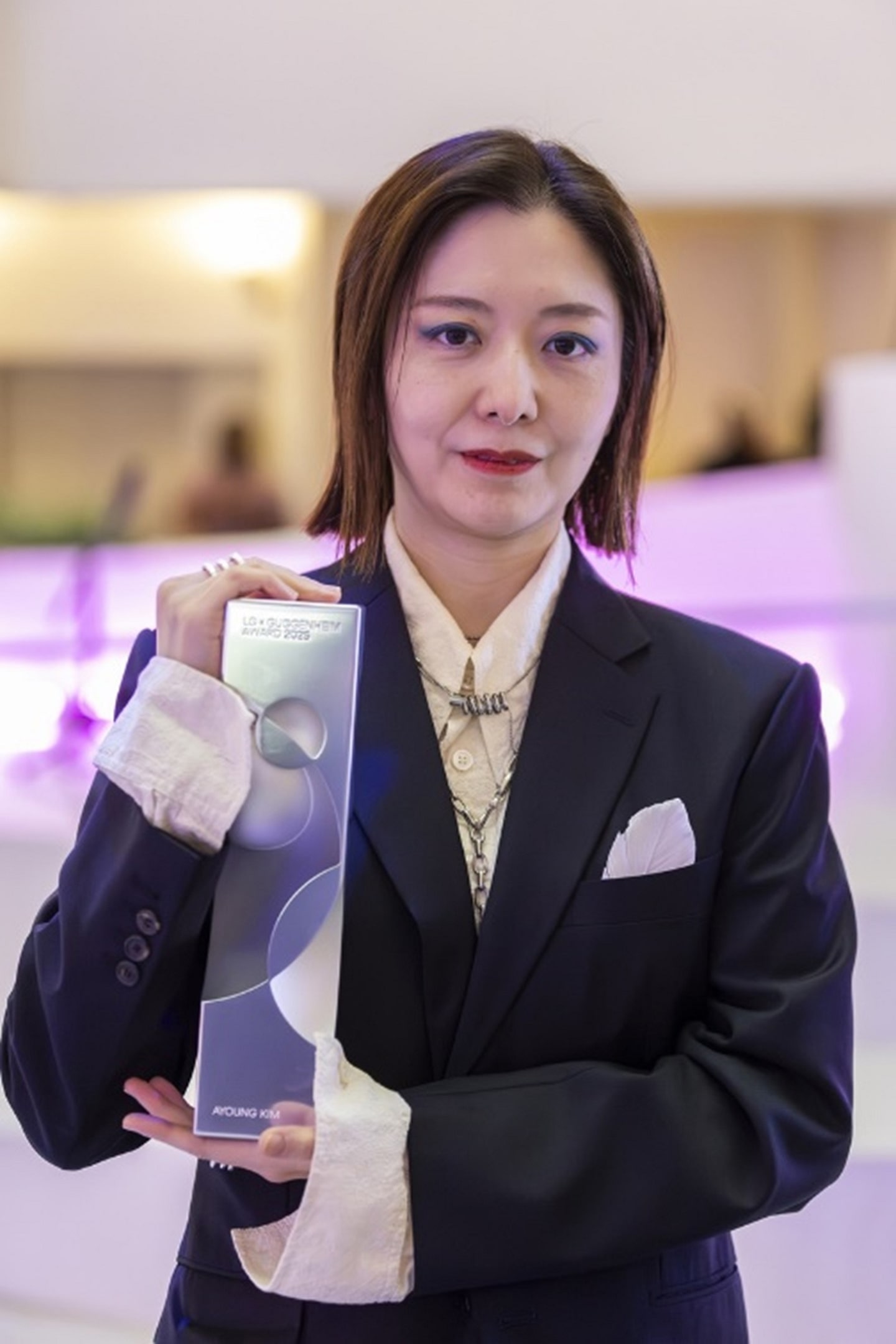 A photo of a woman holding a LG Guggenheim Award