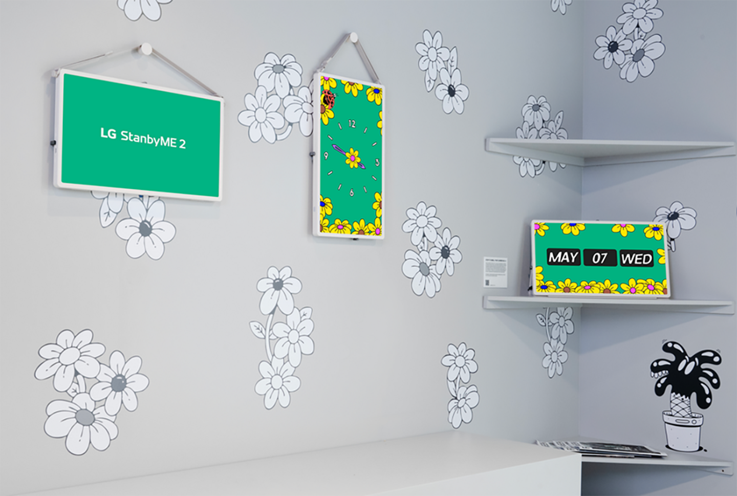 A photo featuring 3 OLED TV, one written 'LG StandbyME 2', a clock with flower frame and the other with a date