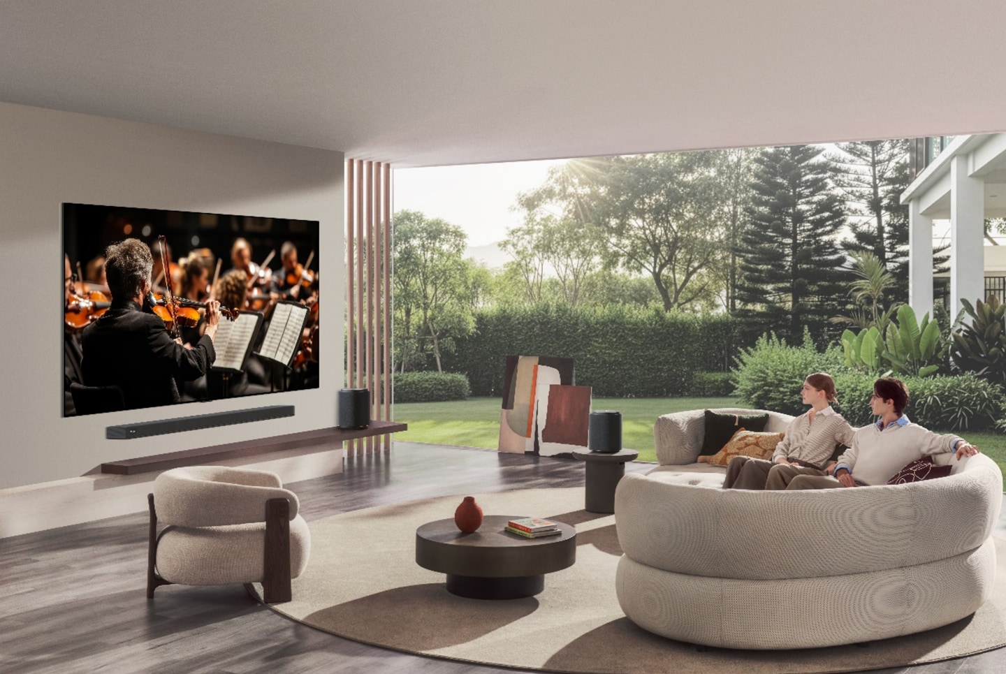 LG OLED evo in a modern living room, displaying a live orchestra performance while two viewers enjoy a home cinema experience.