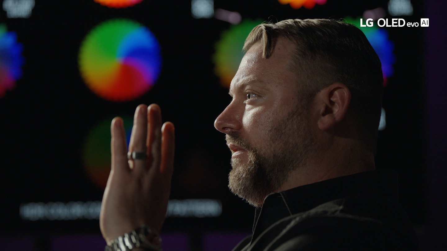 A picture of a man talking with his hand infront of his face