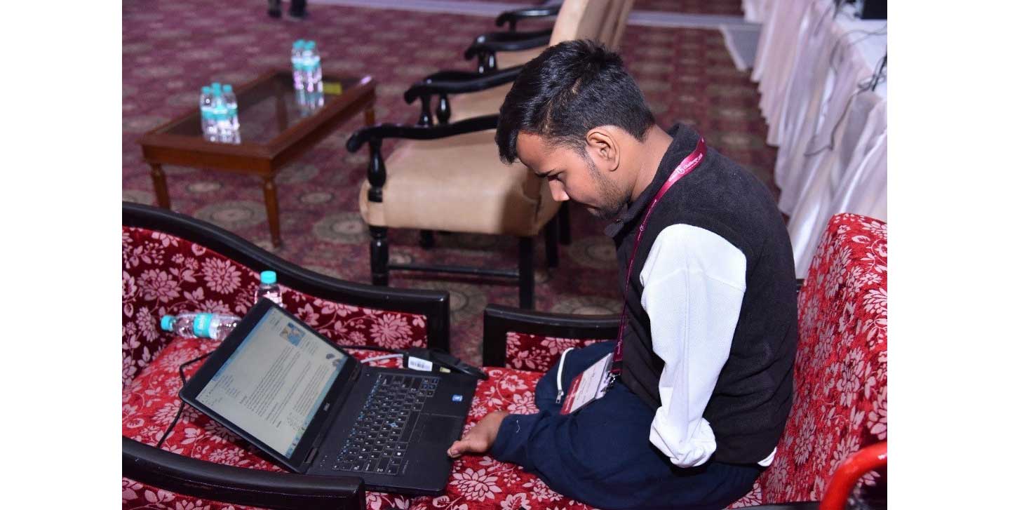 A participant looks down at his laptop computer