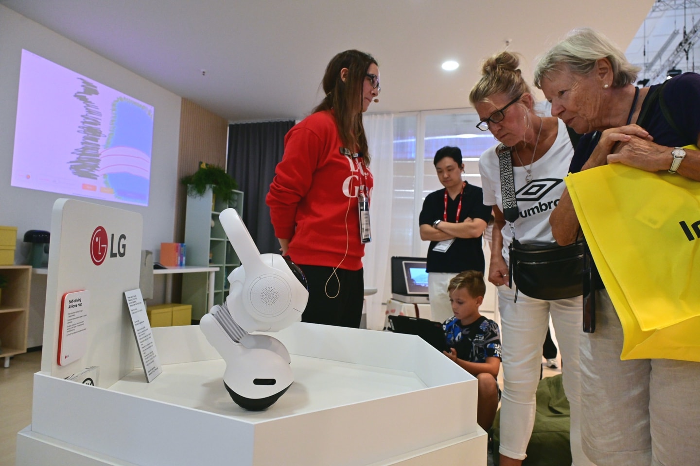 A picture of visitors looking closely at LG's AI products