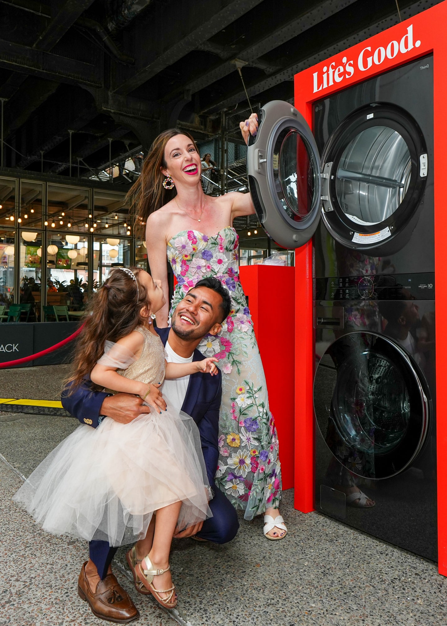A couple and a child in front of LG washing machine