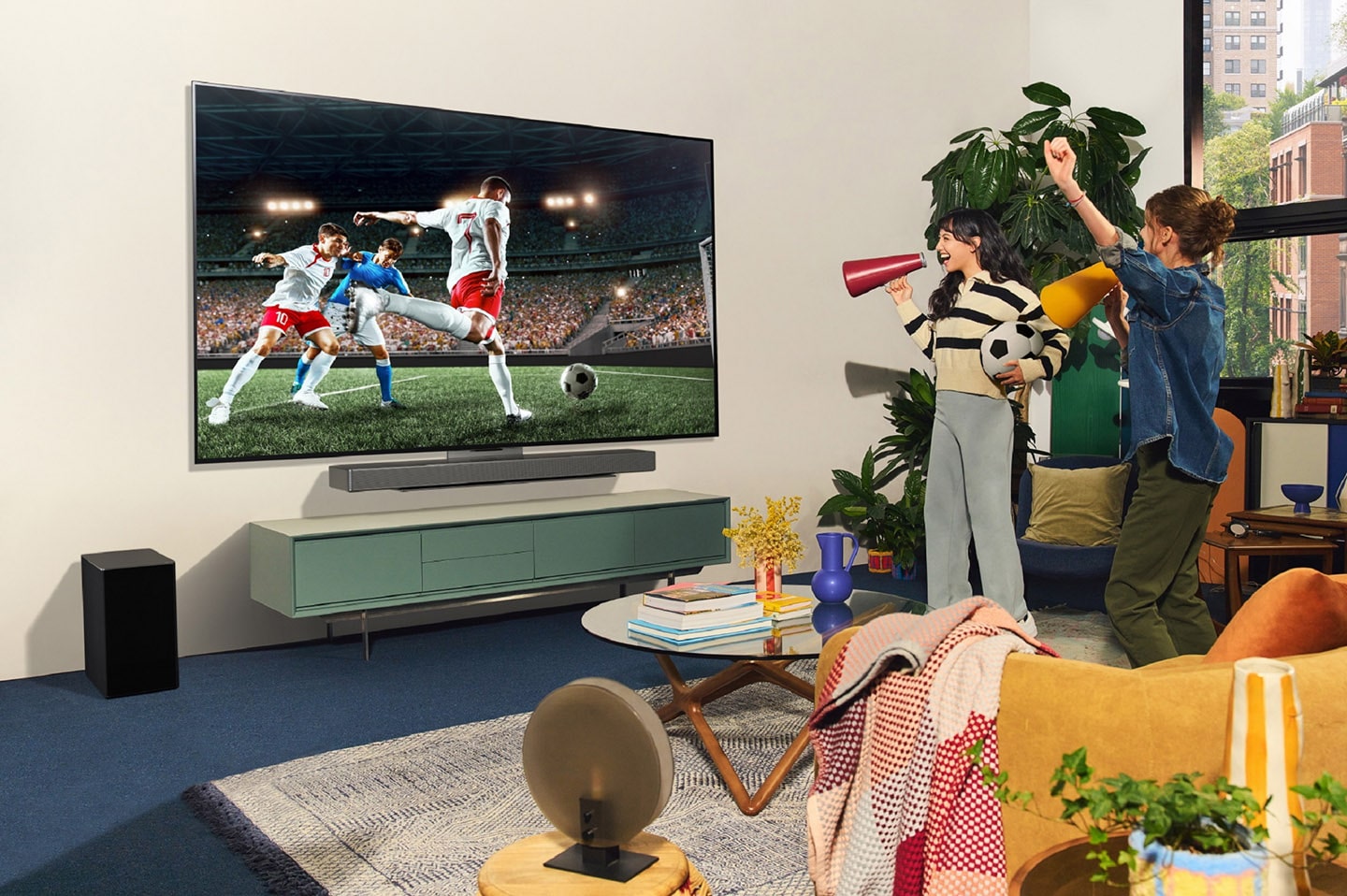 A picture of two women cheering while watching sports on the OLED TV