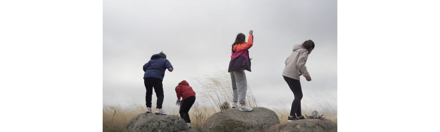Children throwing homemade seed balls into donated lands to plant trees in the area.