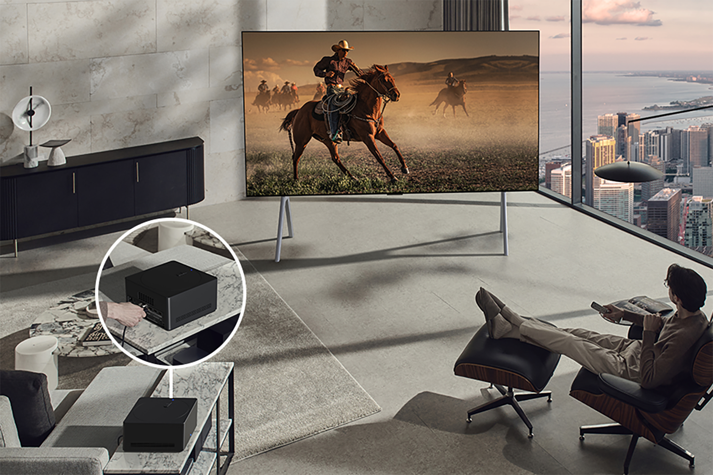 A picture of a man watching the OLED TV screen with the Zero Connect Box next to him