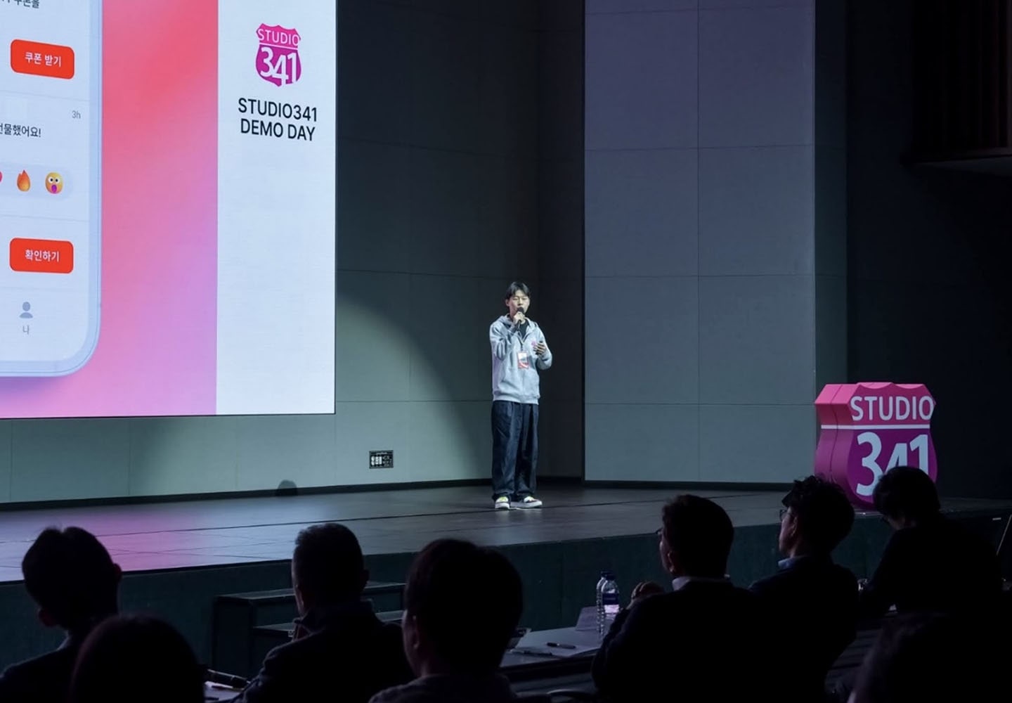 A Photo of Cucumbers Founder Lee Jae-hyuk speaking on stage with a microphone 