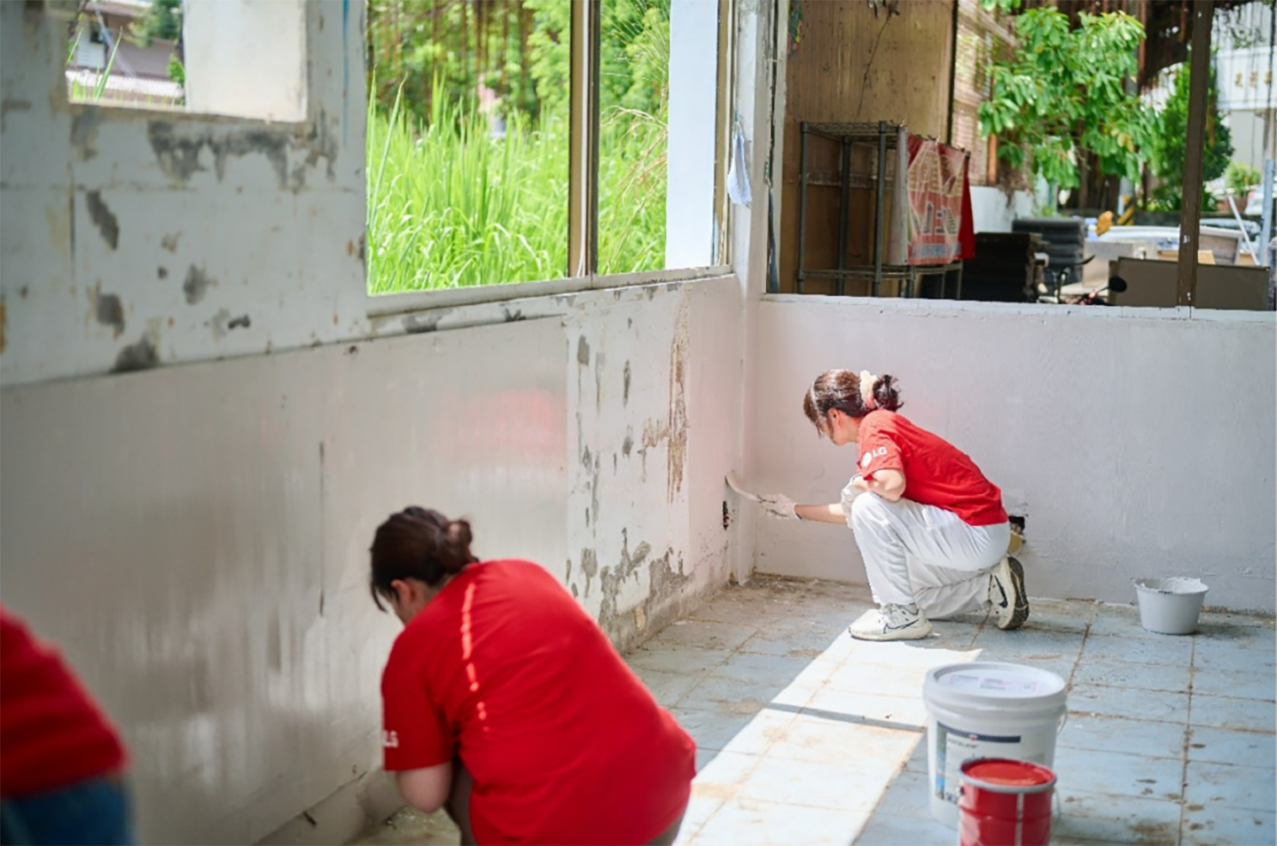 A picture of two LG Taiwan employees painting a wall in the school