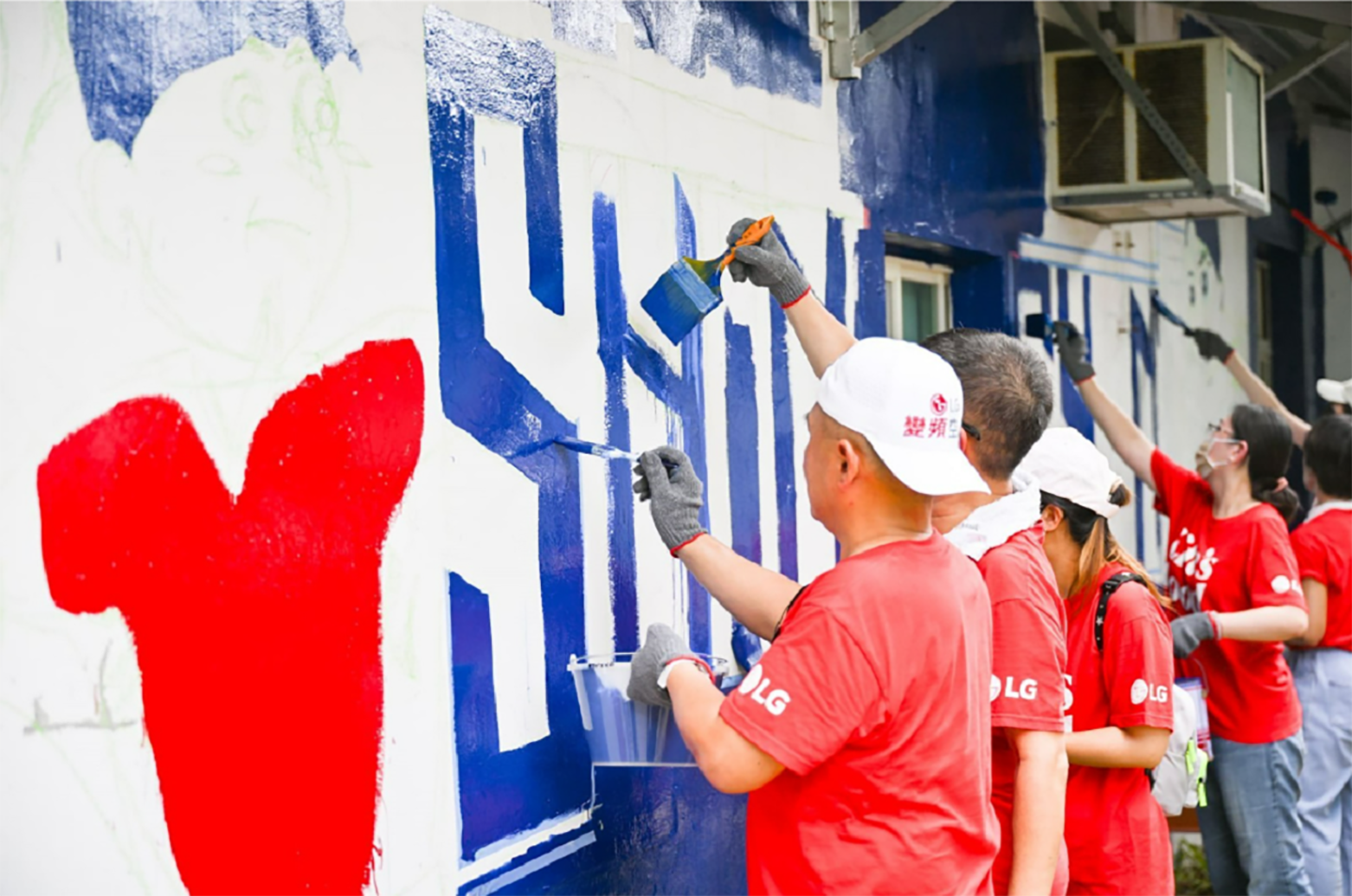 A picture of LG Taiwan employees painting a wall at the school