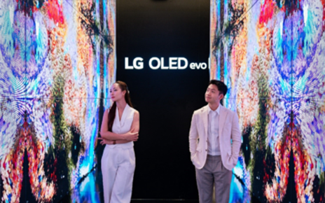 A man and a woman taking a photo in the background of the screen at multi-sensory experience space