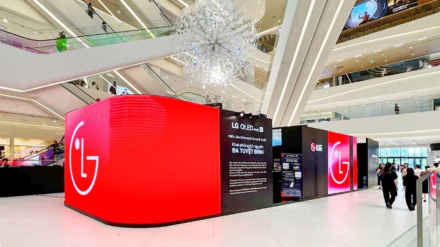 A photo of a digital art exhibition with a red LG logo on the large screen