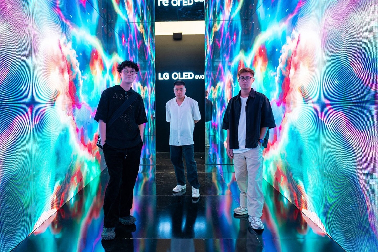 A photo of three guys taking a photo in a stylish exhibition space