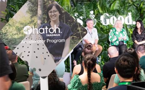 A photo of five people smiling in front of a wall of Life's Good logos