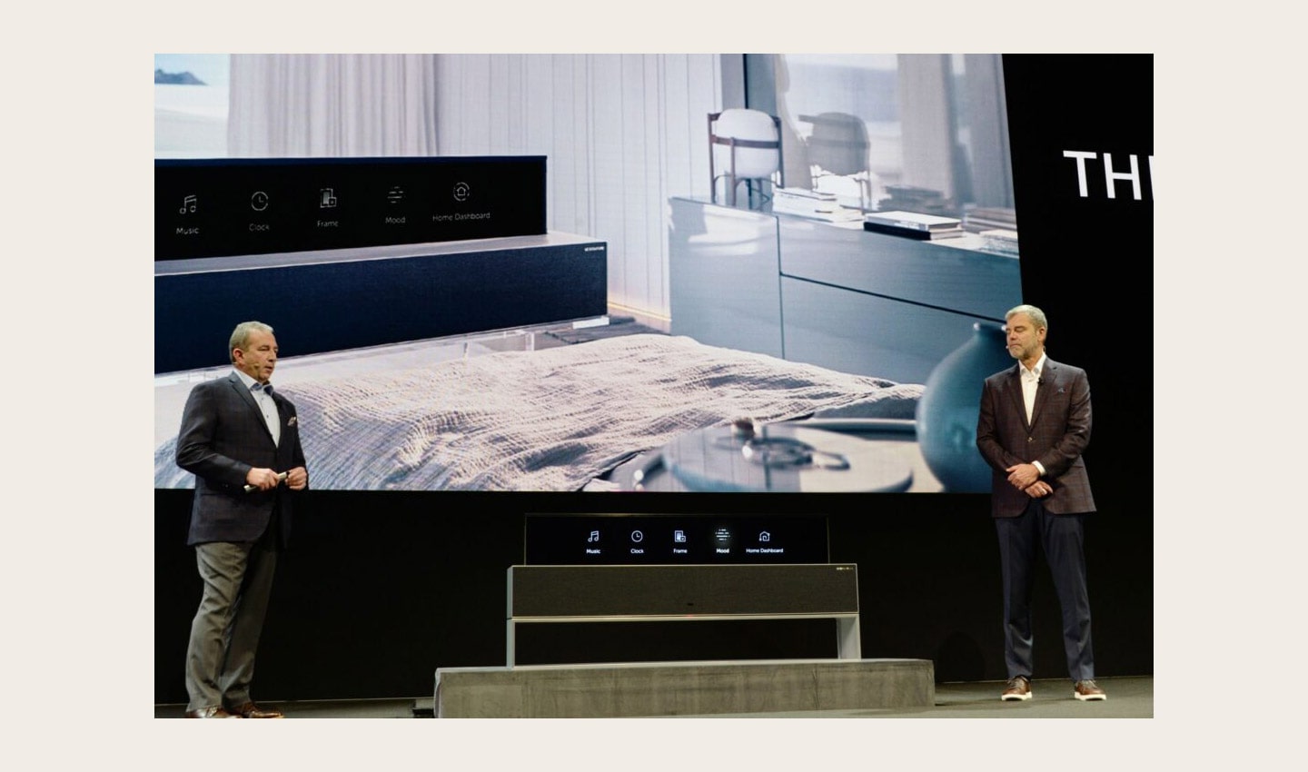 David VanderWall, Senior Vice President of Marketing at LG Electronics USA and Tim Alessi Senior Director of Product Marketing for Home Entertainment Products at LG Electronics USA are onstage demonstrate the half-rolled display position of the LG SIGNATURE OLED TV R at LG's CES 2019 Press Conference while putting the TV between them.
