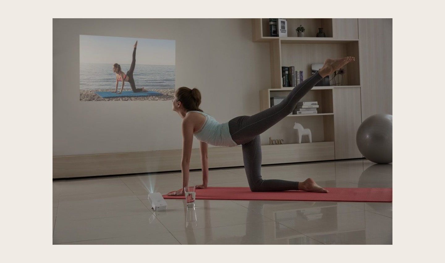 A woman doing yoga while watching a projection from the LG MiniBeam Projector