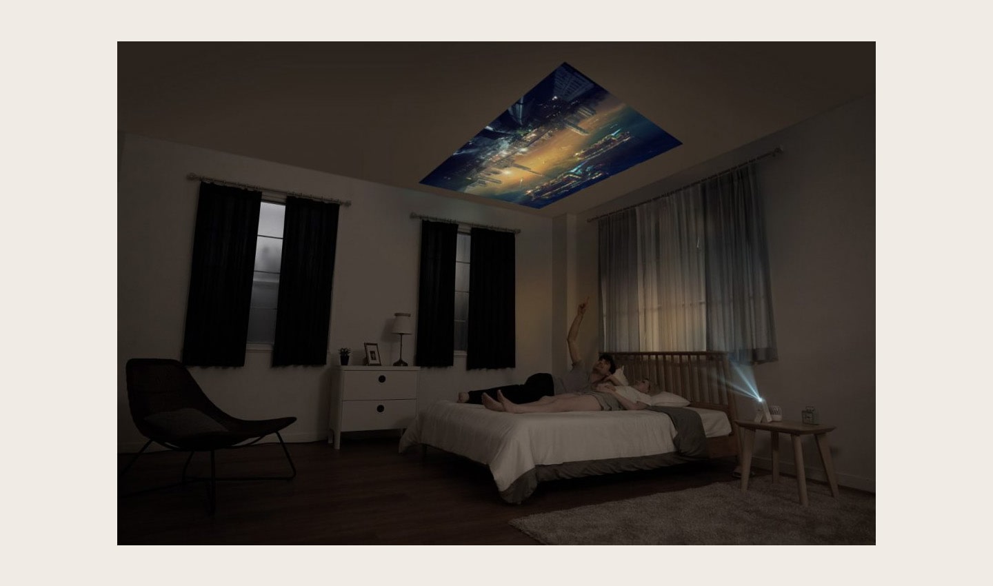 A couple lying in bed while watching a movie projected on the ceiling by the LG MiniBeam Projector