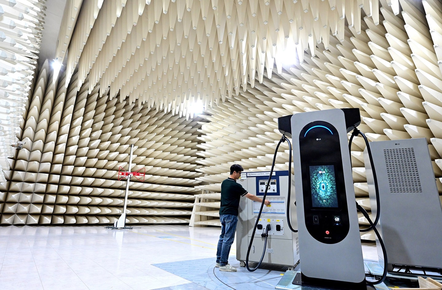A photo of a man examining a machine connected to the LG EV charger