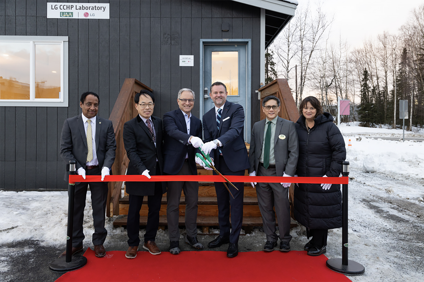 A photo of Professor Getu Hailu (Associate Professor of UAA), Sangok Kweon (Director of LG Electronics research and development), Sean Parnell (UAA Chancellor), Steve Scarbrough (Senior Vice President of LG Electronics USA), Kenrick Mock (Dean of the College of Engineering of UAA), and Suzanne Rigdon (Marketing head of LG Electronics USA) cutting the ribbon  
