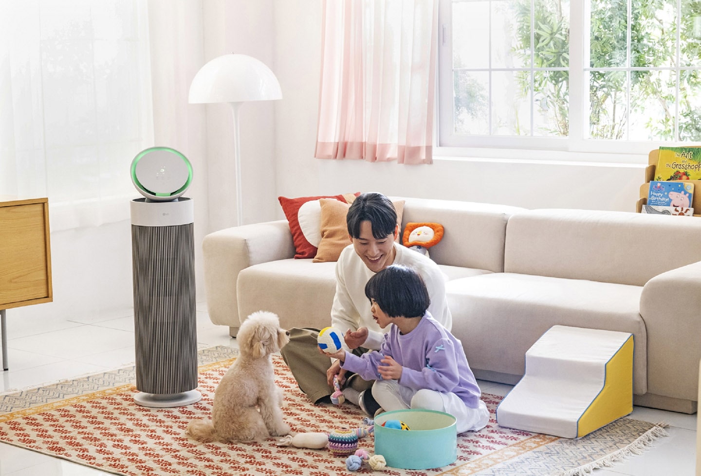 A photo of the LG PuriCare AeroBooster set up in a living room beside a family 