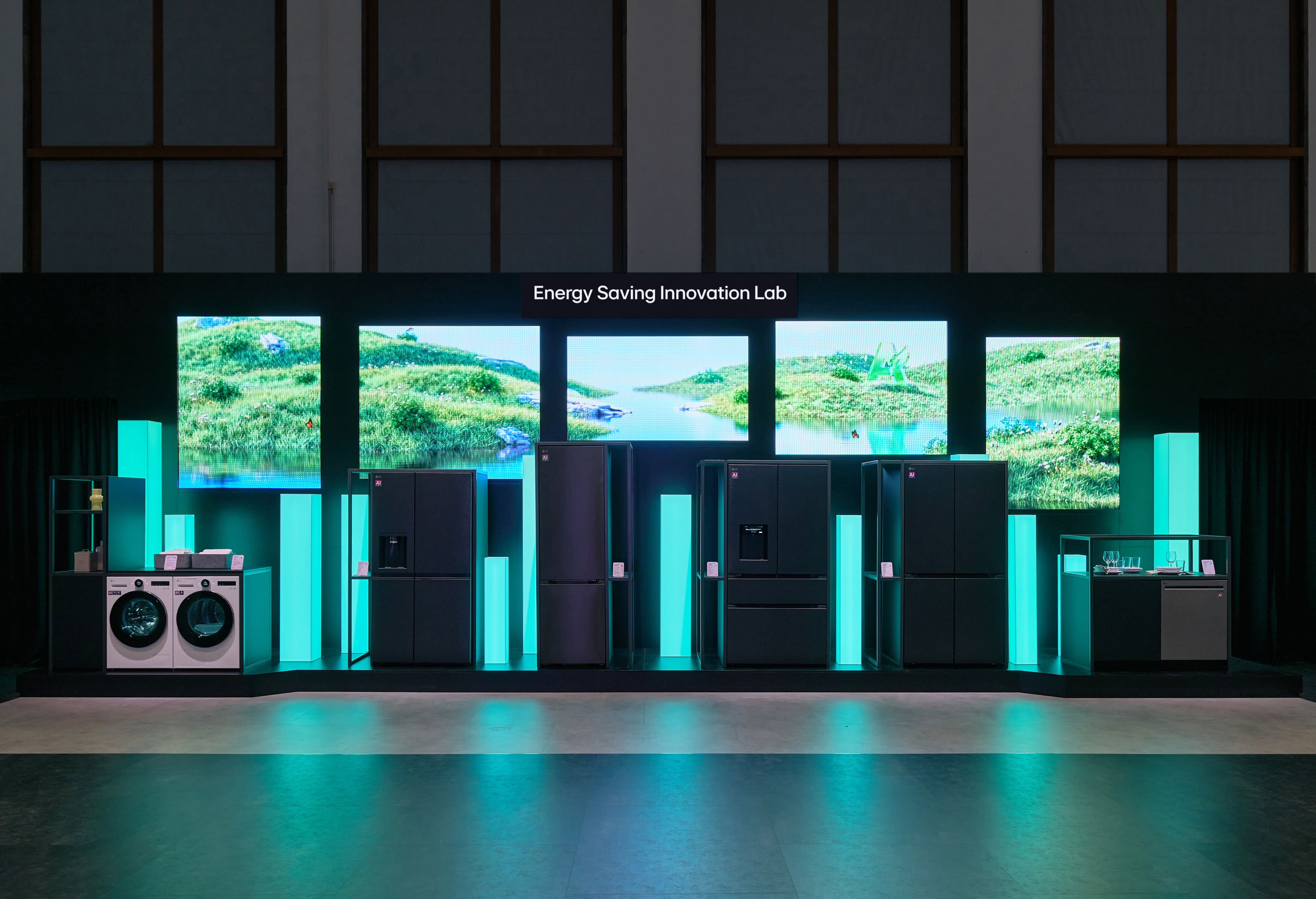 The Energy Leadership Zone at IFA 2026 featuring a lineup of dark-toned, high-efficiency home appliances displayed against vibrant natural landscape screens and illuminated cyan pillars.