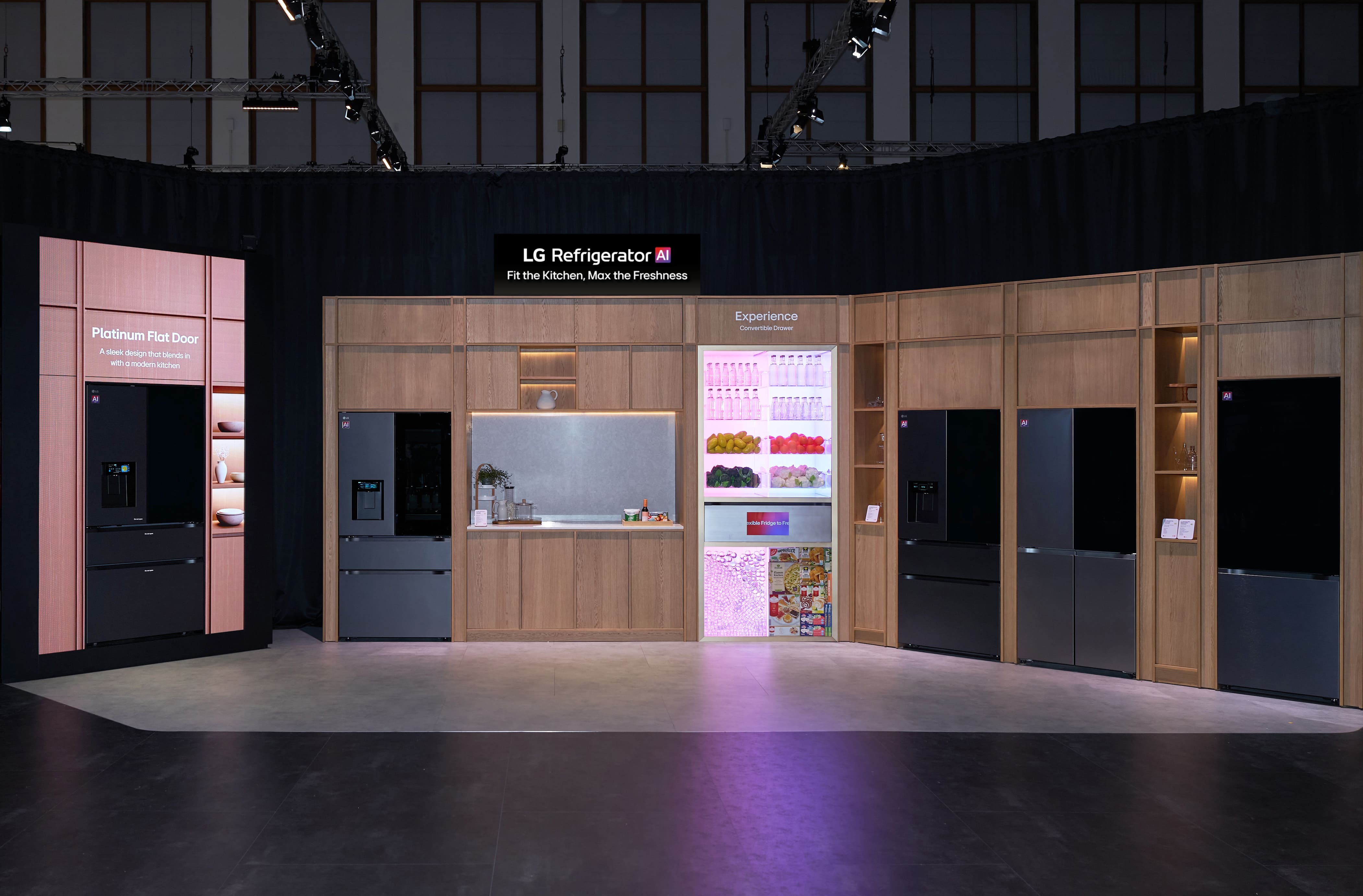 The Fit & Max Solution zone at IFA 2026 featuring sleek, large-capacity refrigerators seamlessly integrated into modern wood cabinetry, with an illuminated transparent-door model showcasing fresh groceries.
