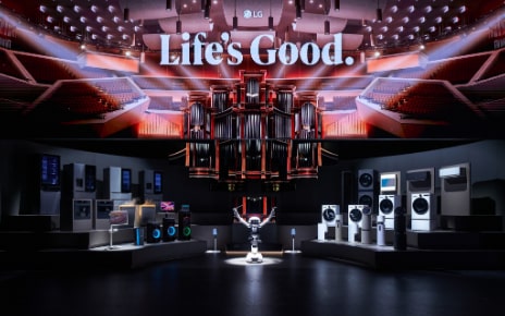 The LG AI Orchestra installation at IFA 2026 featuring a connected ecosystem of home appliances on a tiered stage, with an LG CLOiD robot acting as a conductor beneath a massive LED pipe organ screen.