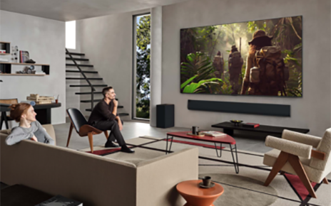 A man and woman enjoying a vivid jungle scene on an LG TV in a stylish, contemporary living space.