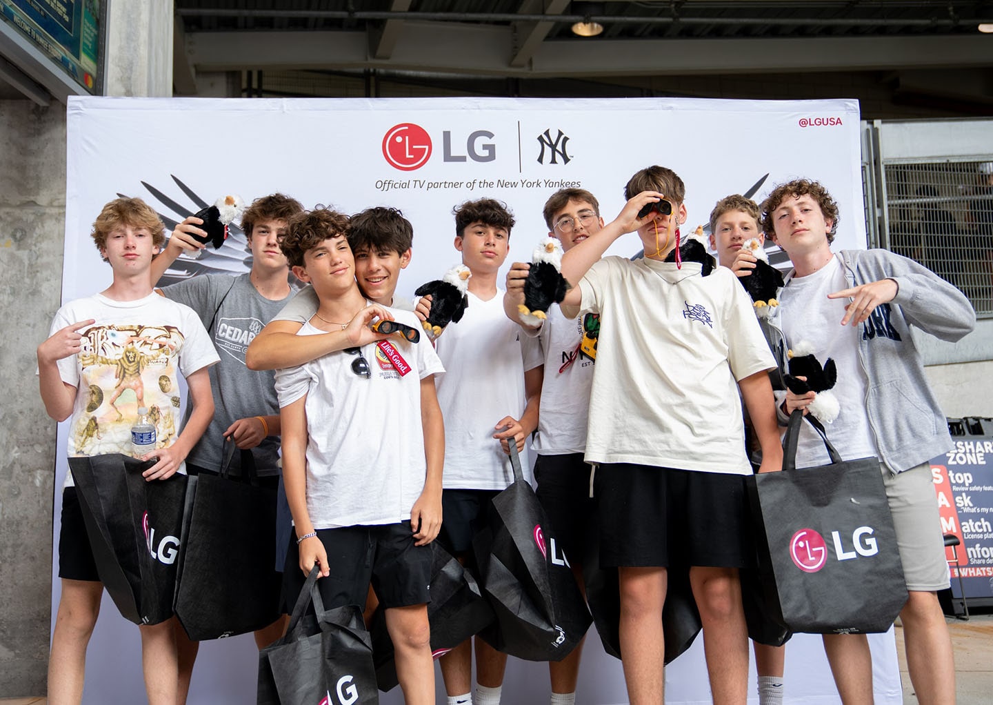 A picture of a group of boys infront of an LG backdrop holding LG goods