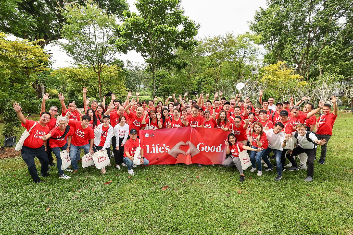 A picture of LG Singapore employees and environmental enthusiasts posing for a group picture wearing LG logo-printed shirts