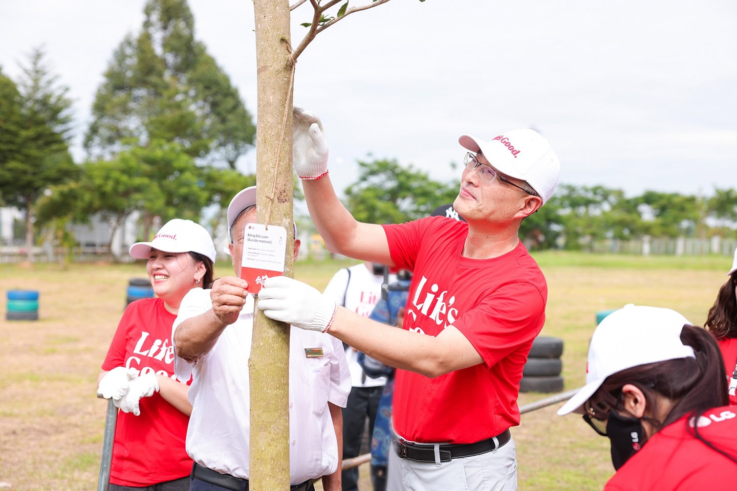 A picture of LG Vietnam employees standing around a tree