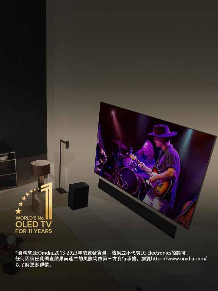 俯視圖：一對男女在現代公寓中透過大型 OLED 電視觀賞音樂會。 圖中亦有「World's number 1 OLED TV for 11 Years」標誌。
