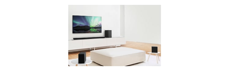 電視和 Sound bar 均在白色客廳，而中央則有一張白色梳化。揚聲器放置在梳化的兩側。