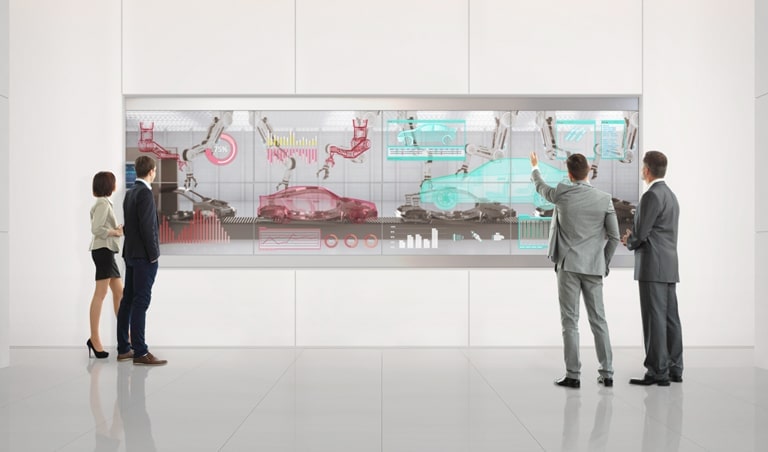 人們使用安裝在大廳牆壁上的透明 OLED 螢幕來分析他們的工作。
