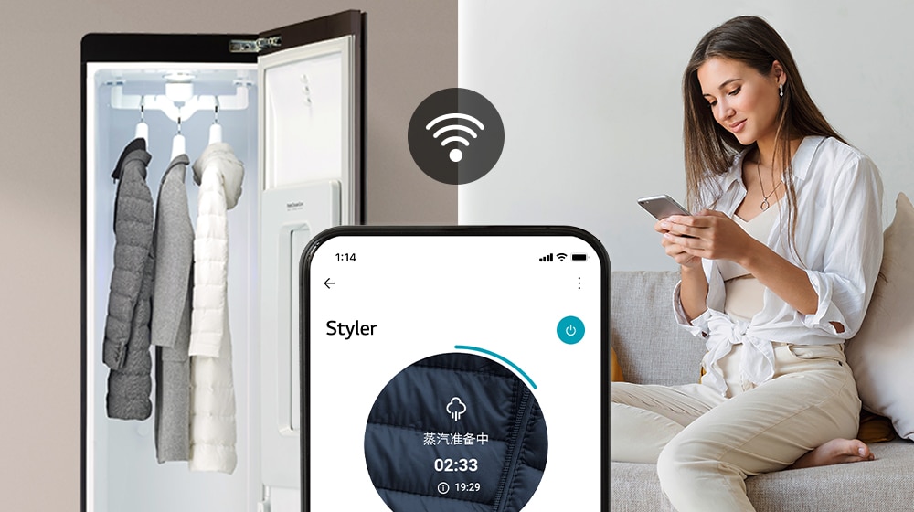 女人正在看手機，她的衣物掛在 Styler 衣物護理機上。