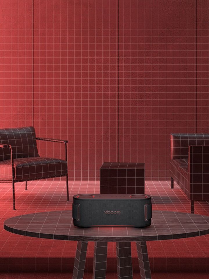 Furniture is placed in a space illuminated by red lighting, with an Xboom on the table in the center, scanning the surrounding space.