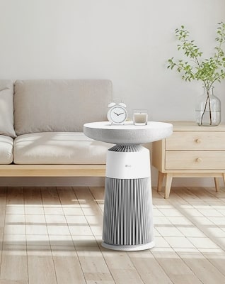 LG Aerospeaker 在明亮客廳的影像，其用作側桌，上面放有時鐘和蠟燭。	