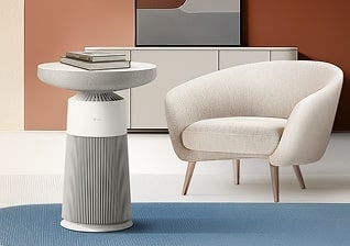 LG Aerospeaker 在現代起居空間的影像，其用作側桌，置於扶手椅旁，上面放有堆疊的書本。	