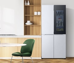 LG 雪櫃擺放於暖色調的廚房中，搭配木製櫥櫃和綠色椅子，與自然室內設計融為一體。