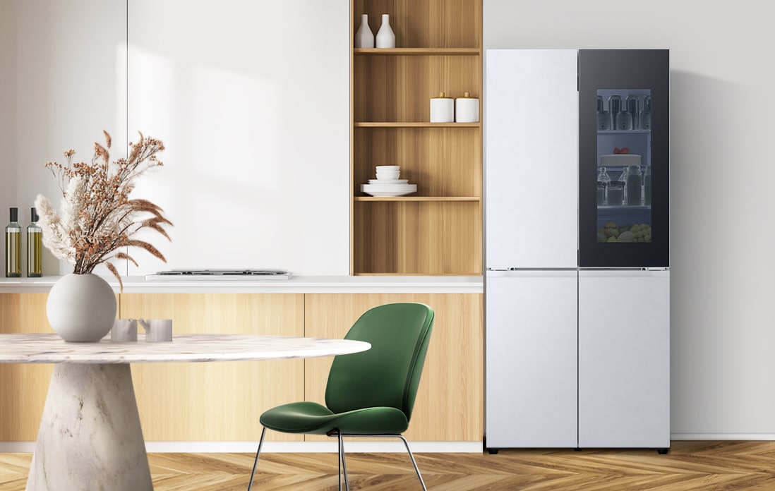 LG 雪櫃擺放於暖色調的廚房中,搭配木製櫥櫃和綠色椅子,與自然室內設計融為一體。