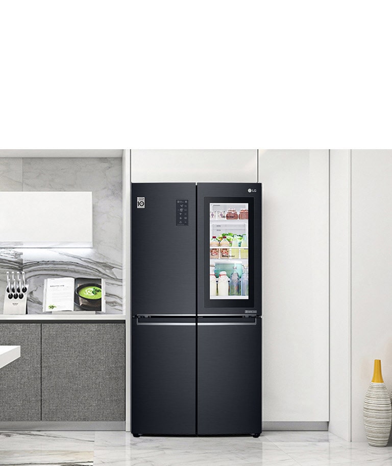 LG 黑色雙門冰箱,內部擺放有食物與飲料,置於現代廚房中,旁邊有書和刀具。