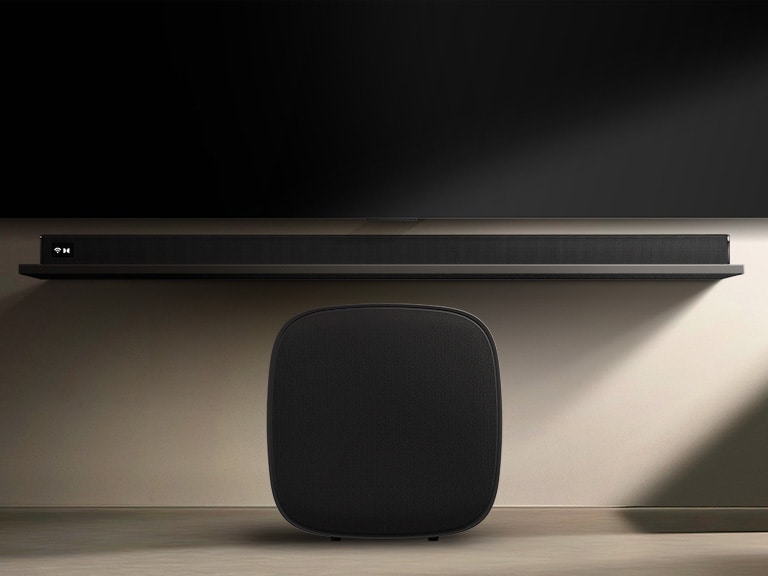 LG Sound Suite W7 低音喇叭置於電視下方,配合 soundbar,顯示輕鬆的無線聲音擴展能力,帶來身臨其境的家庭立體音響系統。