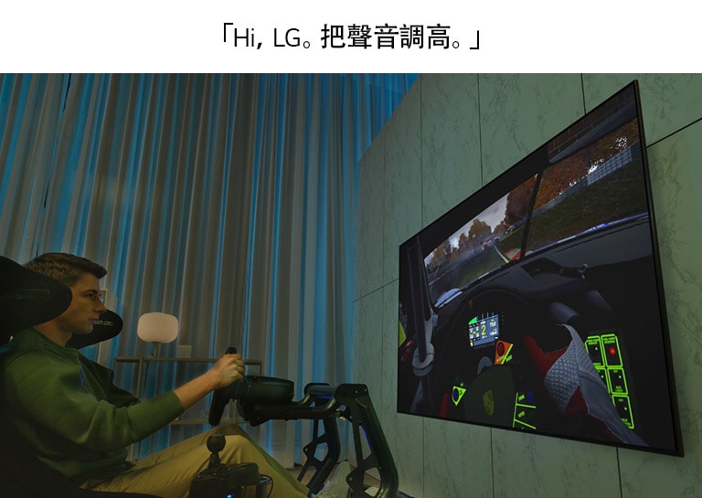 一位男士坐在賽車座椅上在大電視前玩賽車遊戲。