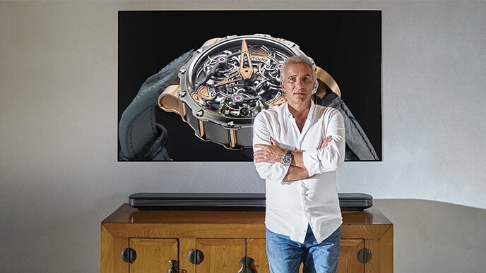 鐘錶匠Antoine Preziuso站在LG SIGNATURE OLED TV W前面。