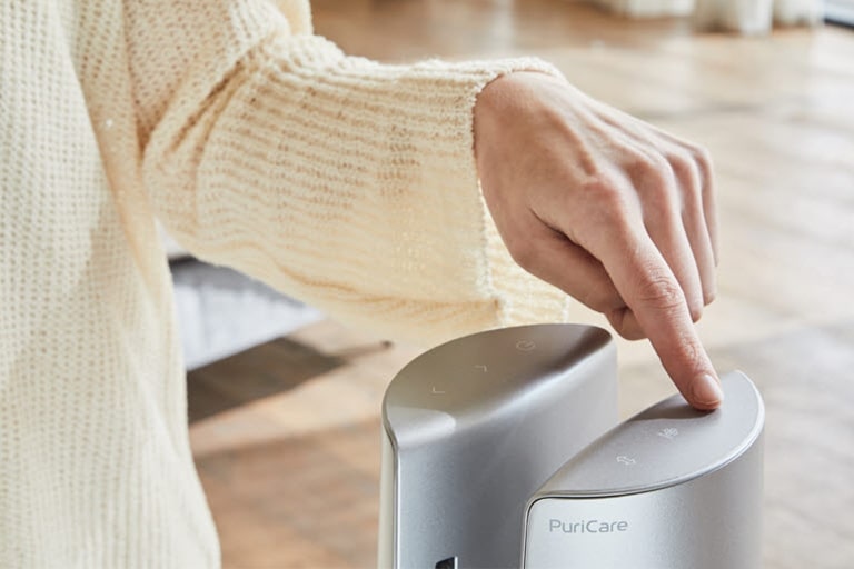 A woman is touching on the top of the product by her finger.