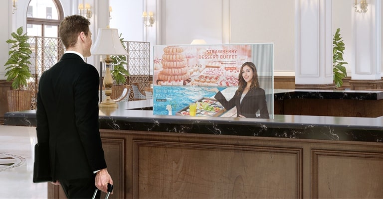 A man is getting information through the Transparent OLED Signage screen showing photos of the dessert menu.