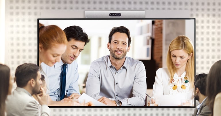 A video conference is being held as people are screened on signage installed on the wall.