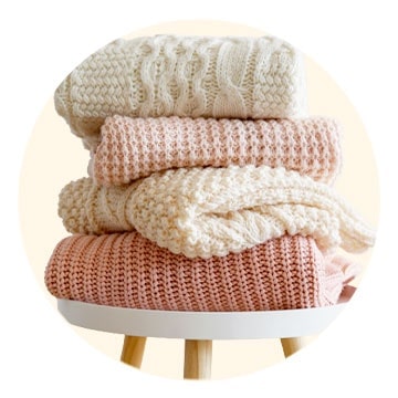 Knits are stacked on the table.