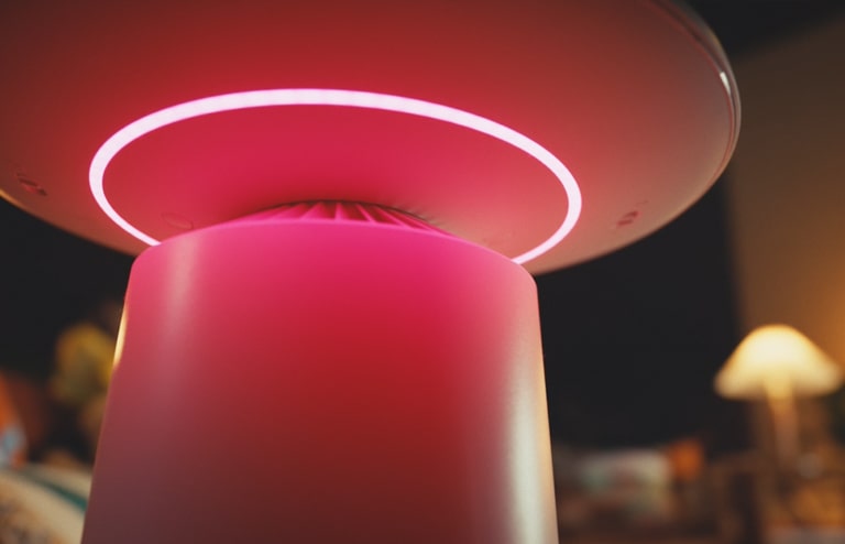 LG appliance with a glowing pink ring light in a dim room, emphasizing its sleek design and ambient illumination.