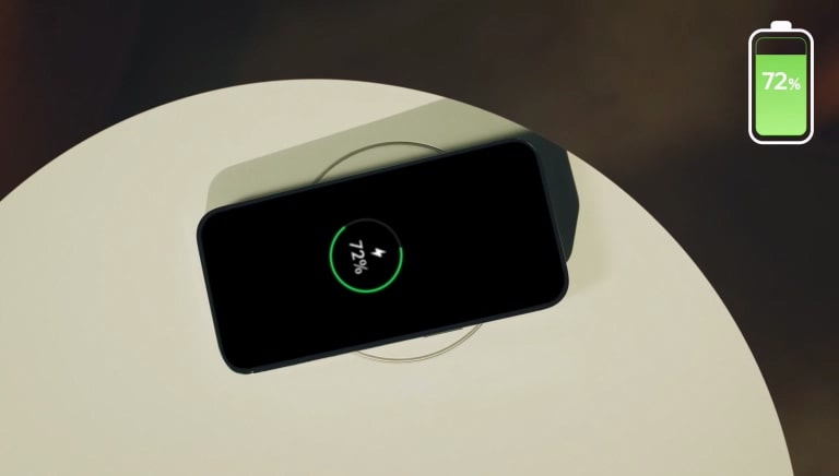 A smartphone on a circular wireless charging pad displays 72% battery, with a similar icon in the top-right corner.